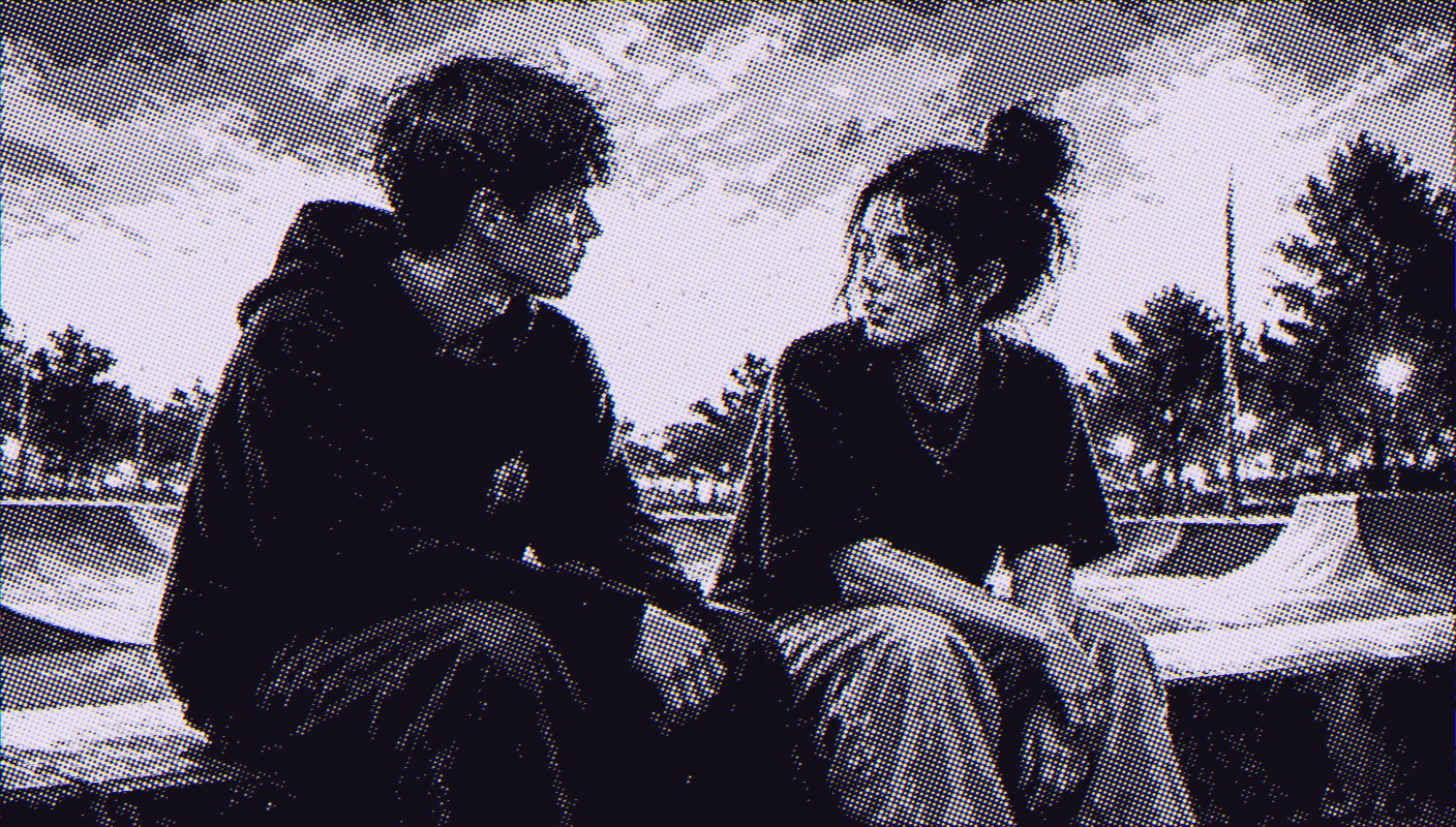 Two teenagers sitting side by side on a skate park ledge at dusk, one listening to the other