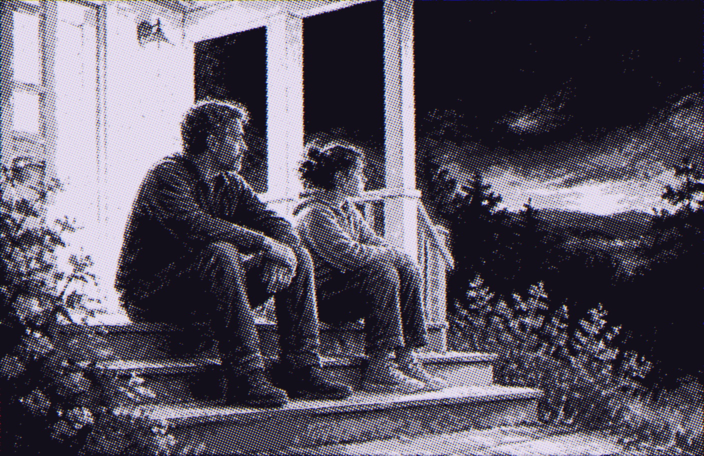 Two people sitting quietly side by side on porch steps at dusk